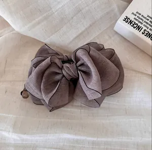 Primer plano de pinza de pelo con lazo de organza multicapa y borde elegante