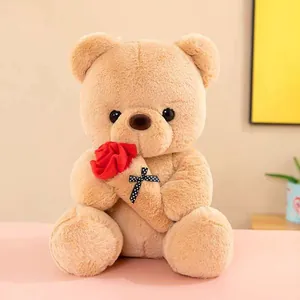 Detailed close-up of a soft beige teddy bear plush toy holding a vibrant red rose decoration