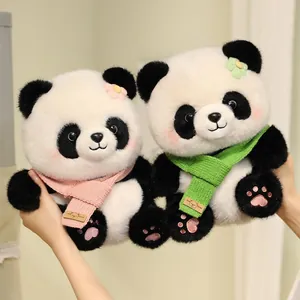 Detail of two soft panda plush toys wearing colorful knitted scarves and flowers.