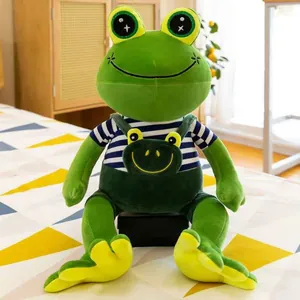 Detailed view of a cute green frog plush toy wearing a striped shirt and green overalls