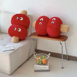 Detailed shot of red Tanghulu plush pillows with cartoon eyes in a cozy home setting