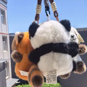 Vista dettagliata di portachiavi in peluche di panda e panda rosso appesi all'esterno