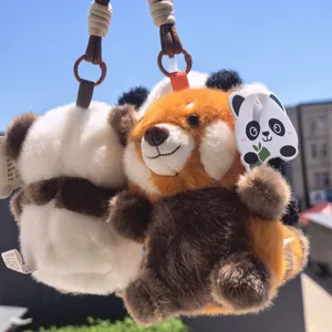 Primo piano di simpatici portachiavi di peluche panda rosso e panda gigante all'aperto