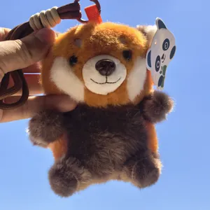 Primo piano di un simpatico portachiavi di peluche panda rosso su sfondo cielo blu