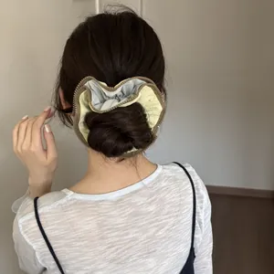 Back view of a model wearing a unique yellow zipper edge hair scrunchie on a bun.