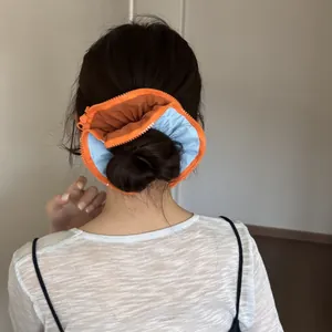 Detailed back view of a large blue and orange zipper scrunchie styled in a hair bun
