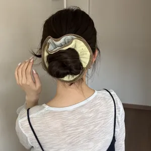 Close-up of a large hair bun styled with a green and brown zipper detail scrunchie