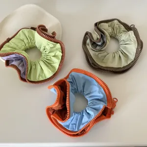 Detailed view of oversized scrunchies with unique zipper edge decoration in various colors.