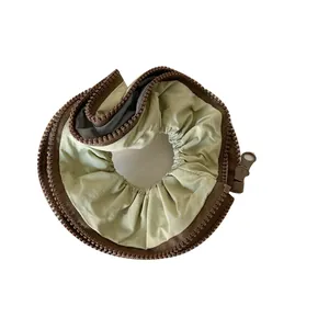 Stylish sage green hair scrunchie featuring a unique brown chunky zipper design