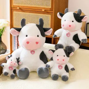 Detailed view of four different sized cute cow plush toys in a cozy home setting