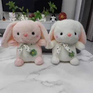 Pair of adorable pink and cream plush bunny rabbits sitting on a white marble surface.