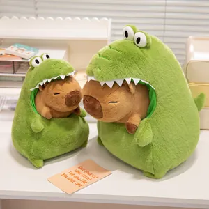 Detail of two cute Capybara plush toys wearing green crocodile onesies on a white desk.