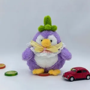 Niedlicher lila Auberginen Pinguin Plüschtier mit Spitzenhalsband und gelber Schleife