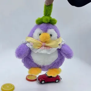 Nahaufnahme eines niedlichen lila Auberginen-Pinguin-Plüschtiers mit Schleife