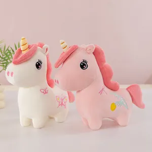 Vista detallada de peluches de unicornio blanco y rosa con lindos bordados de mariposa