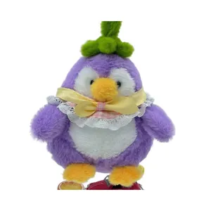 Nahaufnahme eines niedlichen lila Auberginen-Pinguin-Plüschtiers mit Spitzenkragen
