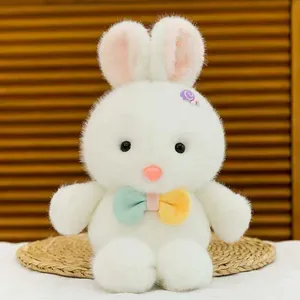 Vista ravvicinata di un morbido peluche a forma di coniglio bianco con un papillon