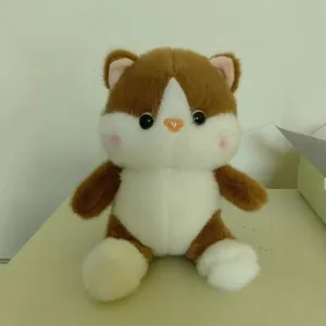 Front view of a cute brown and white kitten plush toy with pink cheeks