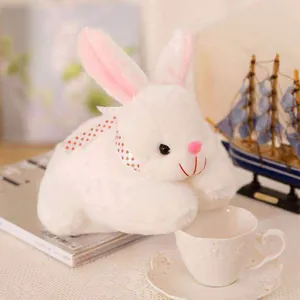 Detailed shot of a soft white plush bunny toy featuring a pink polka dot ribbon