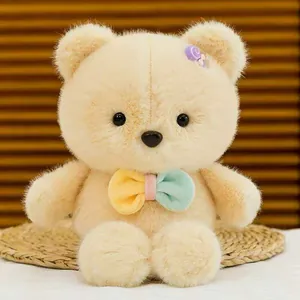 Primo piano dettagliato di un simpatico orsetto di peluche crema con farfallino colorato.