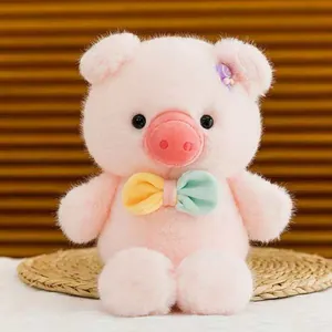 Vista dettagliata di un morbido peluche di maiale rosa con farfallina colorata e clip candy