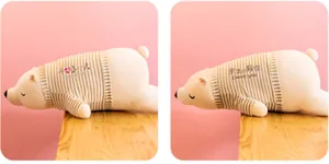 Détail côte à côte de peluches d'ours polaires portant des t-shirts rayés pour enfants.