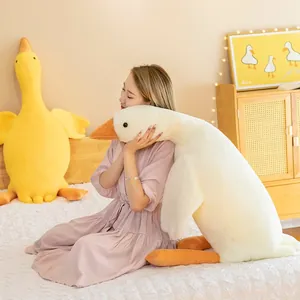 Large white goose plush toy animal pillow being hugged by a model in a warm home bedroom