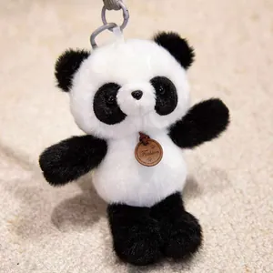 Detailed macro view of a cute black and white fluffy panda plush keychain charm.