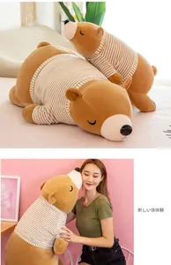 Peluche ours polaire avec pull rayé, tenue par une femme pour un confort douillet.