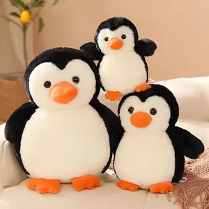 Tres adorables peluches de pingüino en diferentes tamaños sobre un sofá suave