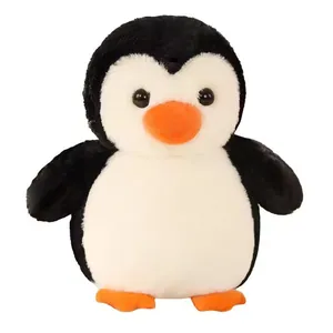 Vista frontal de un lindo peluche de pingüino blanco y negro con pelaje suave y pico naranja