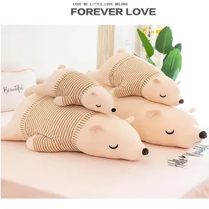 Peluches d'ours polaires mignonnes de tailles variées avec pulls à rayures sur un lit