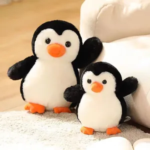 Primer plano de dos suaves peluches de pingüino de diferentes tamaños en alfombra