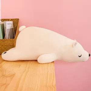 Peluche ours polaire blanc allongée sur une table en bois, doudou doux cadeau pour enfant