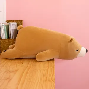 Adorable grande peluche d'ours polaire marron en position allongée sur une table