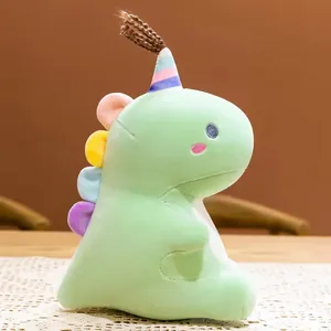 Morbido peluche a forma di dinosauro verde menta con punte colorate e cappellino.