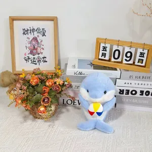 Detail of cute blue dolphin plush toy holding a colorful beach ball in a cozy setting