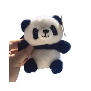 Simpatico portachiavi a forma di panda di peluche tenuto in mano su sfondo bianco
