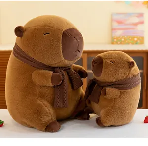 Set of two cute brown capybara plush toys wearing knitted scarves in a cozy home