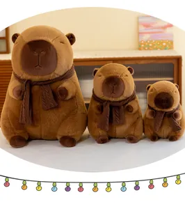 Three sizes of cute brown capybara plush toys wearing knit scarves in cozy home setting