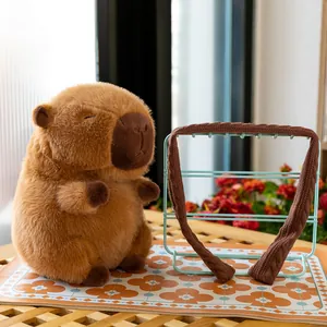 Soft and fluffy brown capybara plush toy sitting on a wooden table outdoors