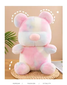 Detailed macro view of a soft colorful tie-dye teddy bear plush toy on a woven mat