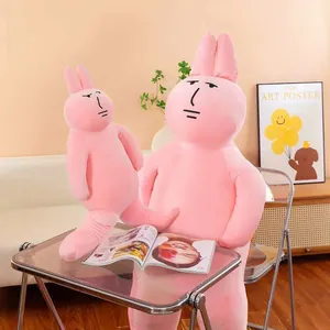 Detail view of funny pink rabbit plush dolls with abstract expressions on a table