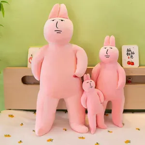 Close-up detail of three quirky pink rabbit plush toy pillows in different sizes