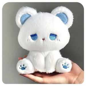 Adorable white plush cat doll with blue sleepy eyes and soft fur held in a hand