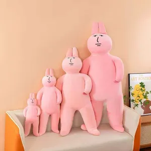 Detailed view of four funny pink rabbit plush toys in varying sizes on a modern beige sofa.