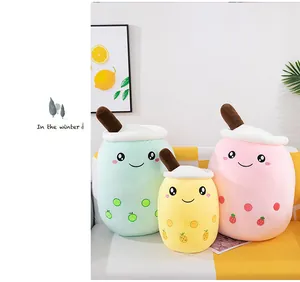 Group of three cute colorful bubble tea cup plush toys displayed on a cozy living room sofa