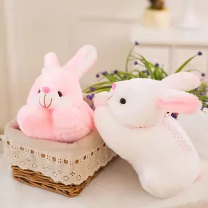 Close-up of pink and white plush rabbits sitting in a lace-trimmed basket for gift display