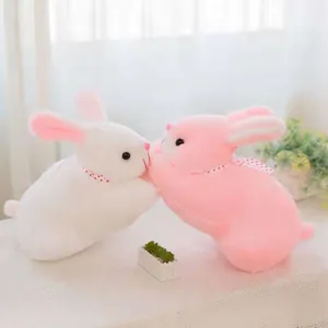Adorable white and pink plush rabbit toys kissing on a table, perfect for children's gifts