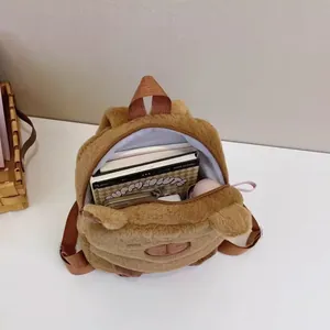 Detailed interior view of a cute brown plush Capybara backpack filled with notebooks.